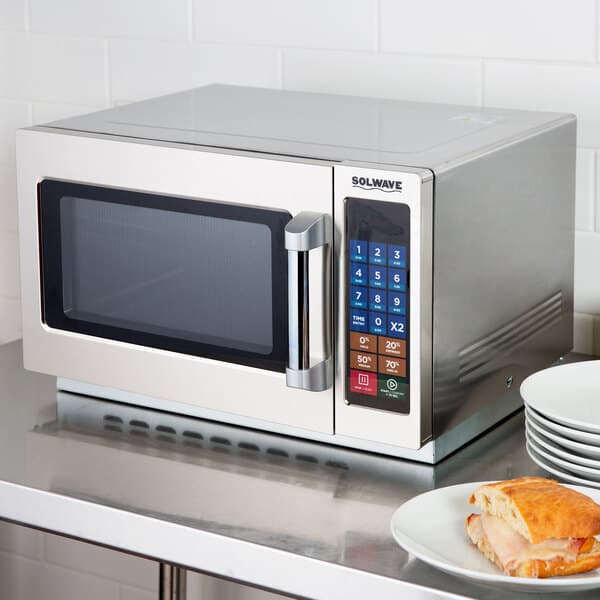 The silver door handle of a Solwave commercial microwave.
